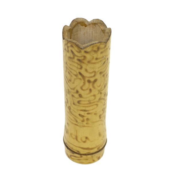 La vue de dessus d'un des vases. Le vase est de couleur jaune et présente un motif tourbillonnant brûlé dans le bambou. 