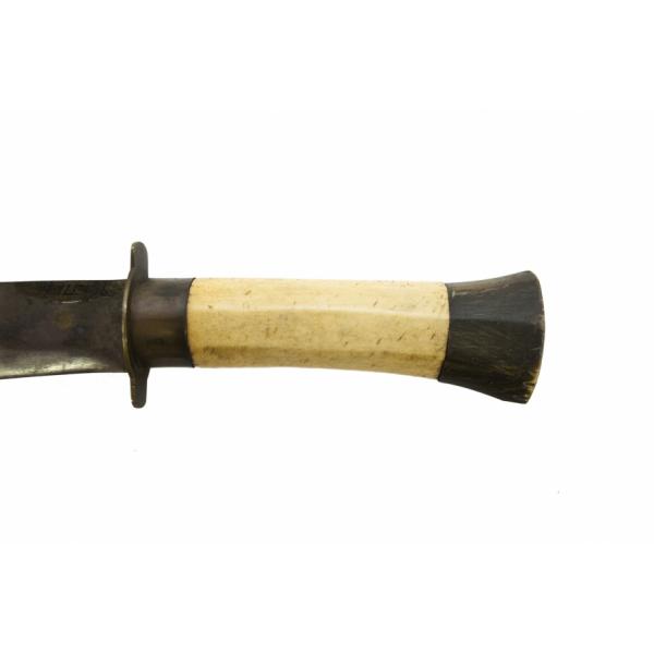 Le manche d'une machette, fait en os avec une base en bois foncé. L’os est beige. Il est fixé à la lame de métal.