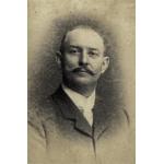 A portrait photo of Jacob Perkins. He has a curled mustache and is wearing a dark jacket over a white-collared shirt. 