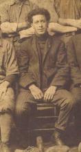 A photograph of International Driller Joshua Porter. He is sitting down and wearing a dark suit.